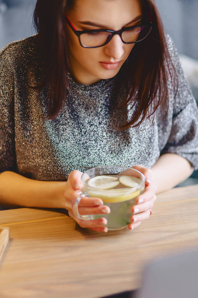 hot tea with lemon in delicate women's hands - Фото, зображення