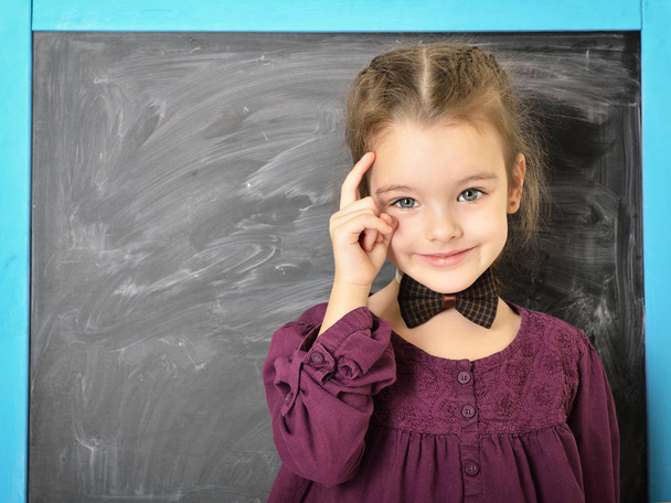 Aranyos liitle lány közelében blackboard, és boldog, mosolyog. Bea - Fotó, kép