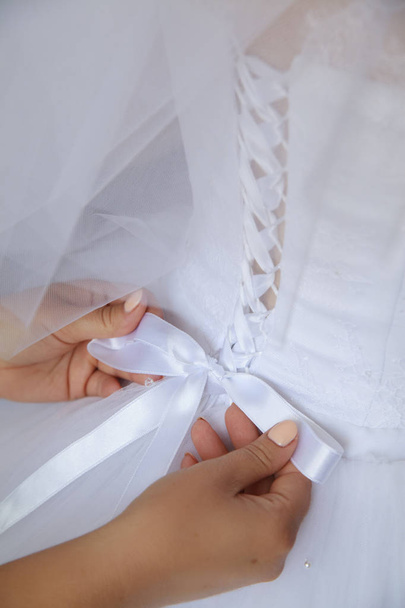結婚式の日。花嫁。ウェディング ドレス レースします。母は、結婚式のコルセットを結び付けます。クローズ アップ - 写真・画像