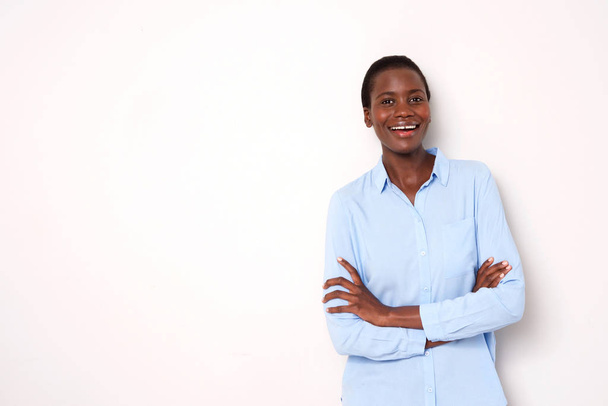 Портрет привлекательной африканской женщины, стоящей со скрещенными руками на белом фоне
 - Фото, изображение
