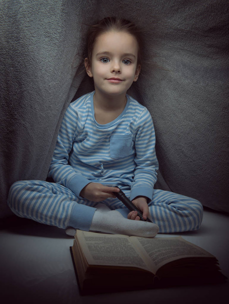 童話を読む少女のイヴにカバーの下に本 - 写真・画像