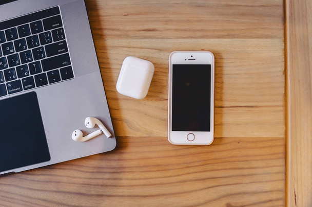 laptop, telefon i bezprzewodowy zestaw słuchawkowy na drewnianym stole - Zdjęcie, obraz