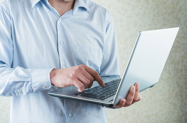 Nahaufnahme eines Mannes in Freizeitkleidung, der Text auf Laptop tippt  - Foto, Bild