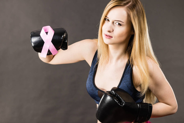 Woman wearing boxing gloves having pink ribbon - Foto, imagen