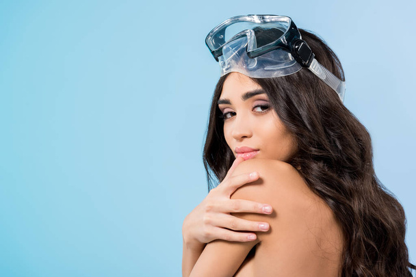 attractive tanned girl posing in goggles, isolated on blue - Photo, Image