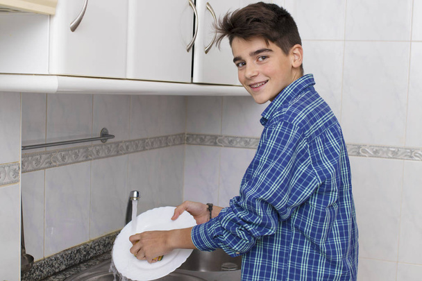 boy, young, teenager or preteen scrubbing the dishes - Zdjęcie, obraz