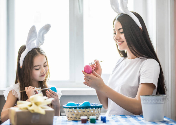 Madre e sua figlia dipingono uova. Buona famiglia che si prepara per Pasqua. - Foto, immagini