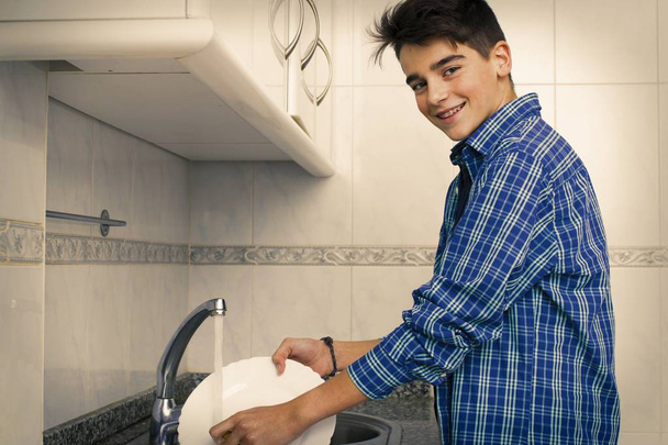 niño, joven, adolescente o preadolescente fregando los platos
 - Foto, Imagen