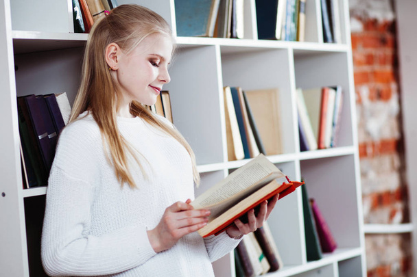 Teenage girl in a library - Фото, зображення