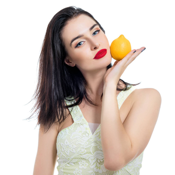 Excited beautiful girl holding lemon and posing in studio over w - Фото, зображення