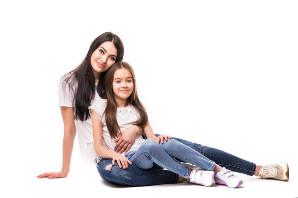 Portrait of happy white mother and young daughter lying on the floor isolated on white background. Happy family people concept. - Fotó, kép