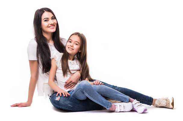 Porträt einer glücklichen weißen Mutter und ihrer kleinen Tochter, die isoliert auf weißem Hintergrund auf dem Boden liegen. Konzept glücklicher Familienmenschen. - Foto, Bild