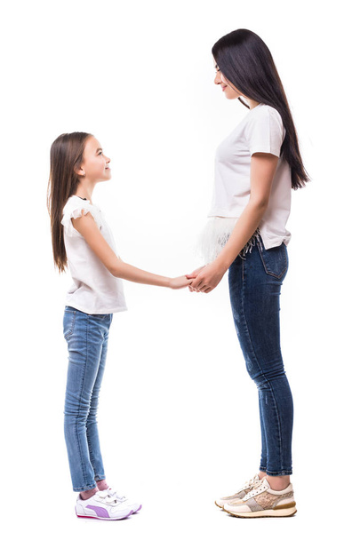 Mutter und Tochter halten sich die Hände zueinander und lächeln isoliert auf weißem Hintergrund - Foto, Bild