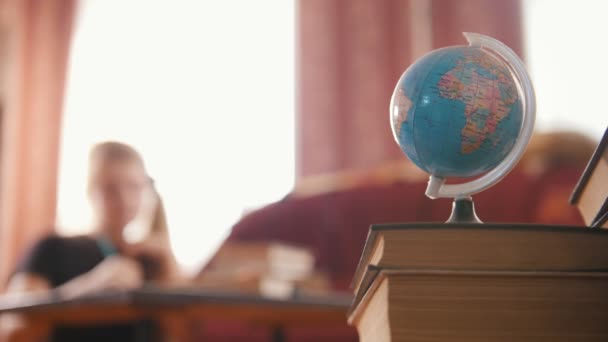 Globe ja kirjoja pöydällä
 - Materiaali, video