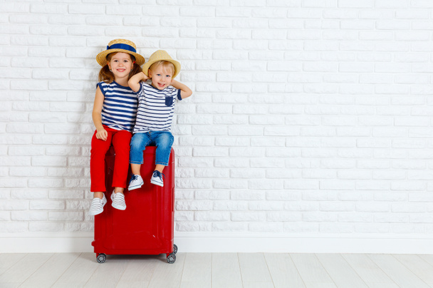 gelukkige lachende kinderen met koffer gaan op een reis - Foto, afbeelding