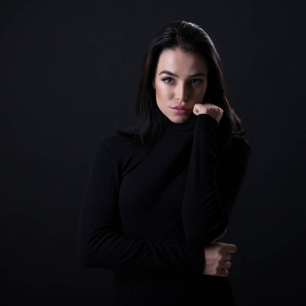 Beautiful girl posing over black background. Young pretty woman  - Fotoğraf, Görsel