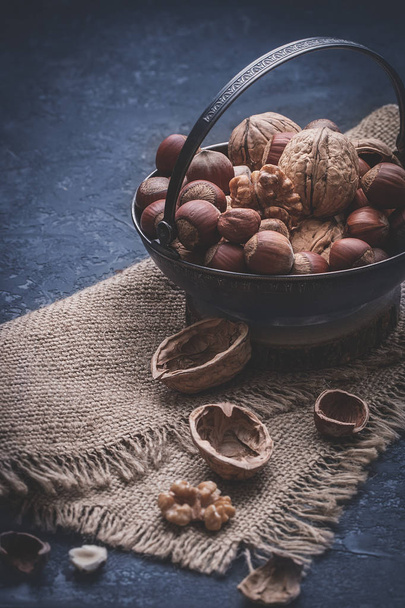     Different nuts on dark stone table. hazelnut, walnuts - Photo, image
