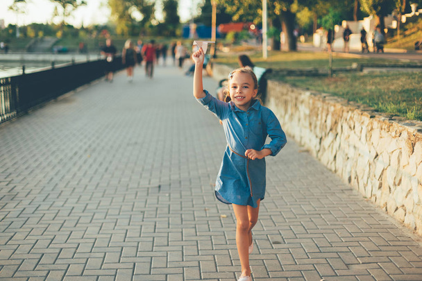 Menina jogando, correndo com avião de papel de brinquedo
  - Foto, Imagem
