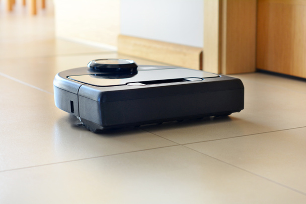роботизированный пылесос на светлом кафельном полу
 - Фото, изображение
