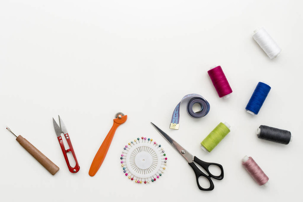 Scrivania sartoriale. Modello di accessori per cucire e strumenti su sfondo bianco vista dall'alto copyspace
 - Foto, immagini