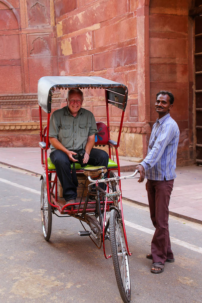 AGRA, INDIA - NOVEMBER 8: Unidentified man stands by his pedicab - Zdjęcie, obraz