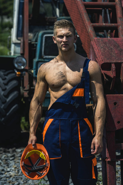 Sexy man with nude torso near construction equipment or excavator - Foto, Bild