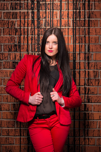 Attractive brunette in a red pant suit - Photo, Image
