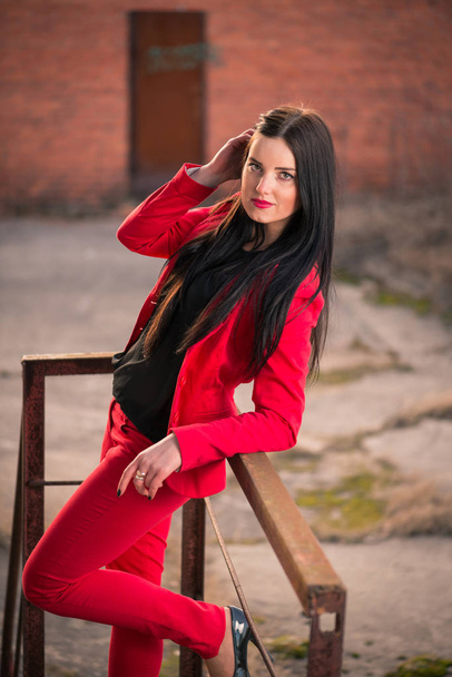 Ελκυστική μελαχρινή σε ένα κόκκινο παντελόνι κοστούμι - Φωτογραφία, εικόνα