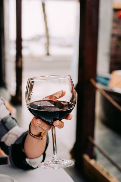 Woman hand holding a wine glass with red wine - Zdjęcie, obraz
