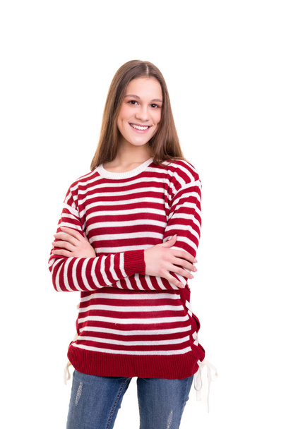 beautiful young woman wearing striped warm sweater and jeans posing with crossed arms isolated on white background - Foto, Imagen