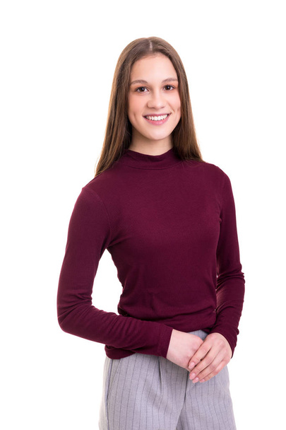 attractive young businesswoman in dark sweater and grey pants looking at camera while posing isolated over white background - Photo, Image