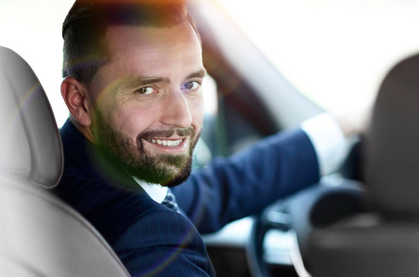 Close-up of a businessman sitting at the wheel of a car - Foto, imagen