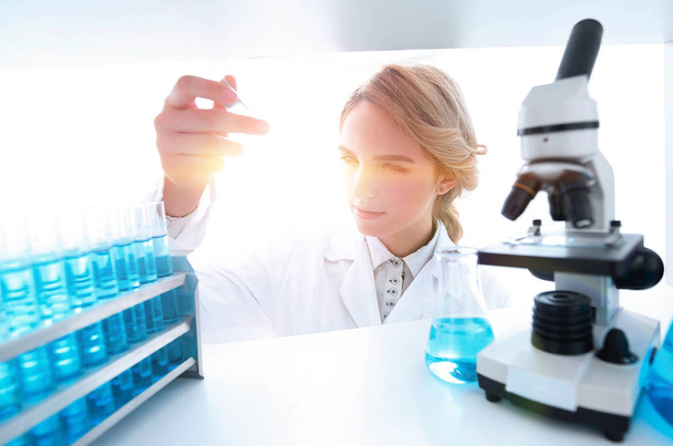 Young woman analyzing samples in a lab - Фото, зображення