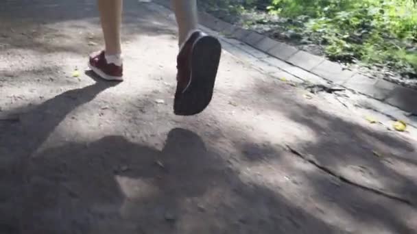 Blonde jonge vrouw joggen in een park, achteraanzicht - Video