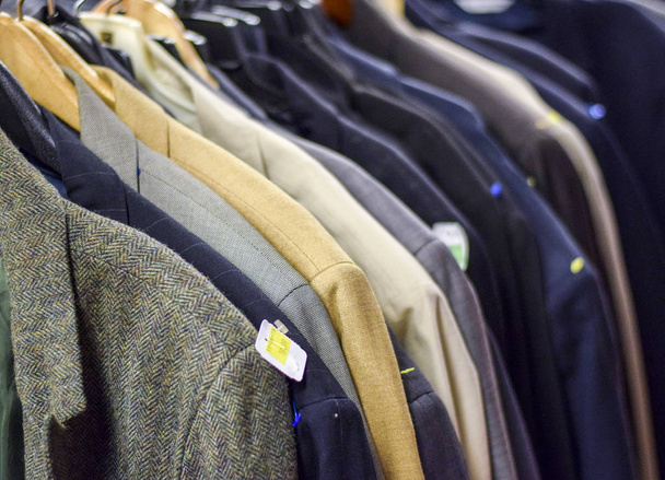 Cremalheira de jaquetas de terno masculinas penduradas na loja de butique
 - Foto, Imagem