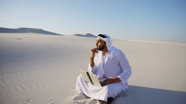 Educado hombre musulmán árabe Emiratos Árabes Unidos Sheikh arquitecto se sienta con gadg
 - Foto, imagen
