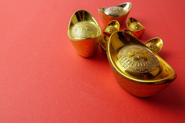 Золоті зливки для святкового прикраси китайський новий рік на червоному тлі. Китайський символ означає, що удача, багатство і процвітання, як видно на зображенні. - Фото, зображення