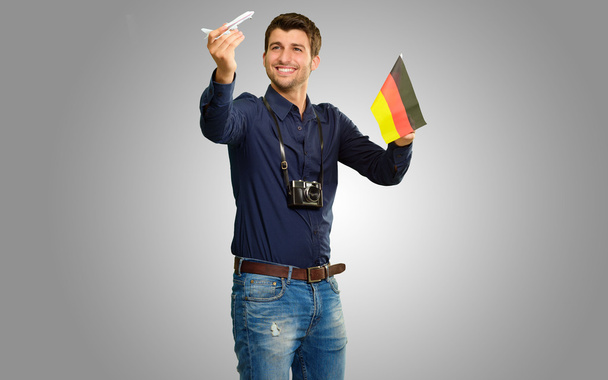 fotograaf holding Duitse vlag en miniatuur vliegtuig - Foto, afbeelding