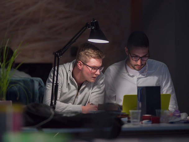young designers working on a new project in the night startup office using modern technology - Foto, Bild