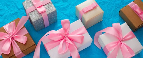 Banner decorativo sfondo festivo con scatole regalo. Sfondo strutturato caramelle blu. Piatto lay vista dall'alto
 - Foto, immagini