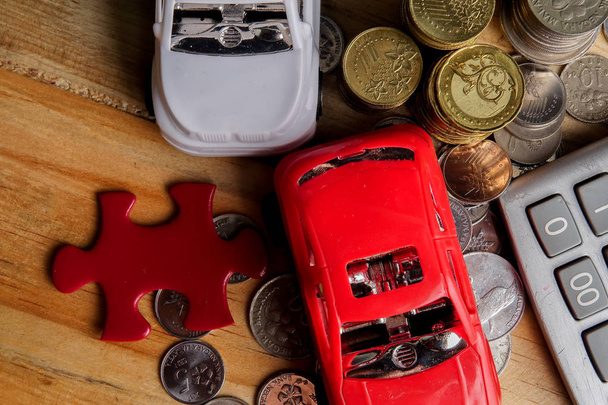 Auto financiering Concept: Kleine auto's, munten, stukje van de puzzel en calculator op houten tafel. Kopiëren van ruimte - Foto, afbeelding