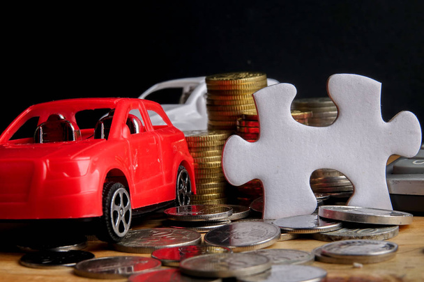 Auto-Finanzierungskonzept: Kleinwagen, Münzen, Puzzleteil und Taschenrechner auf Holztisch. Kopierraum - Foto, Bild