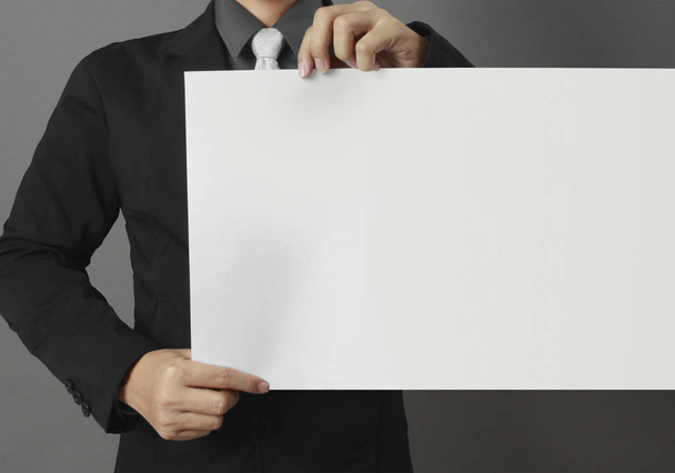 Hand holding white blank paper sheet mockup - Foto, imagen