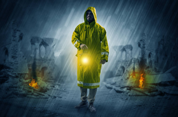 Man with a glowing lantern at a catastrophe scene - Fotó, kép