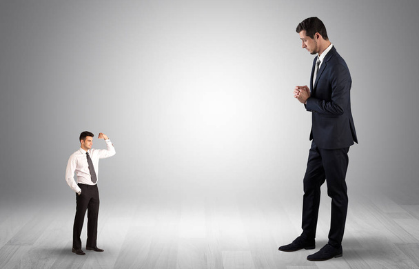 Giant businessman scared of small businessman - Foto, Imagen