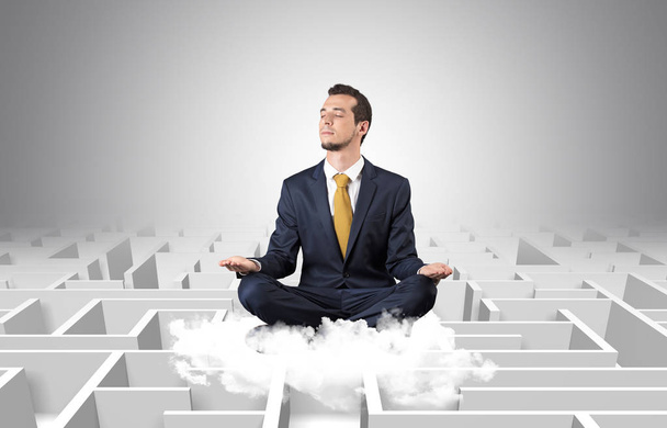 Businessman meditates on a cloud with maze concept - Foto, Imagen