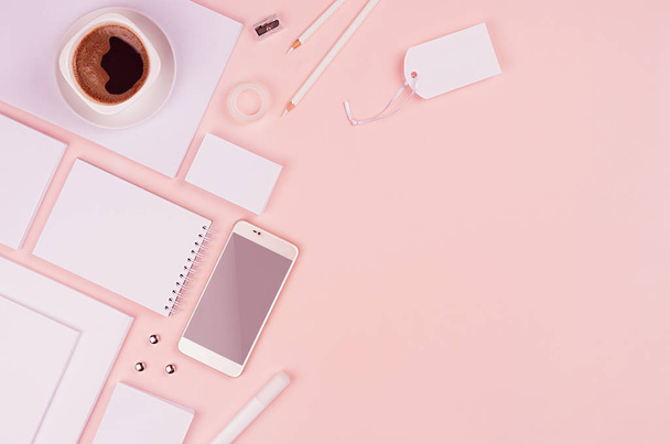 Stylish working space with coffee cup, phone and blank white stationery on pastel soft pink background, copy space. Template for your design. - Photo, Image