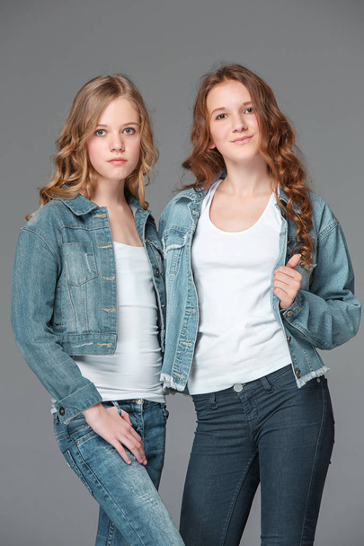 Full length of young slim female girl in denim jeans on gray background - Zdjęcie, obraz