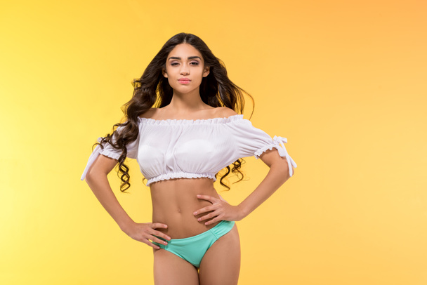 beautiful tanned girl posing isolated on yellow - Foto, imagen