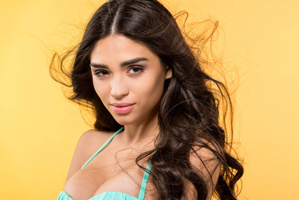 beautiful tanned brunette girl posing in bikini, isolated on yellow - Photo, Image